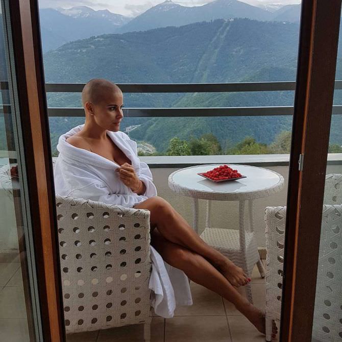 Жена топлесс сидит в номере на балконе фото
